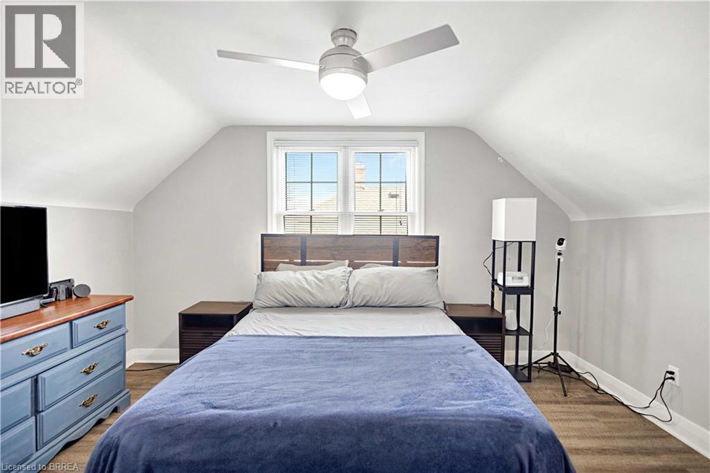 Bright bedroom featuring wood-finish flooring, a contemporary ceiling fan with integrated lighting, and a double window - 371 Ottawa Street S, Kitchener, ON - Indoor Photo Showing Bedroom