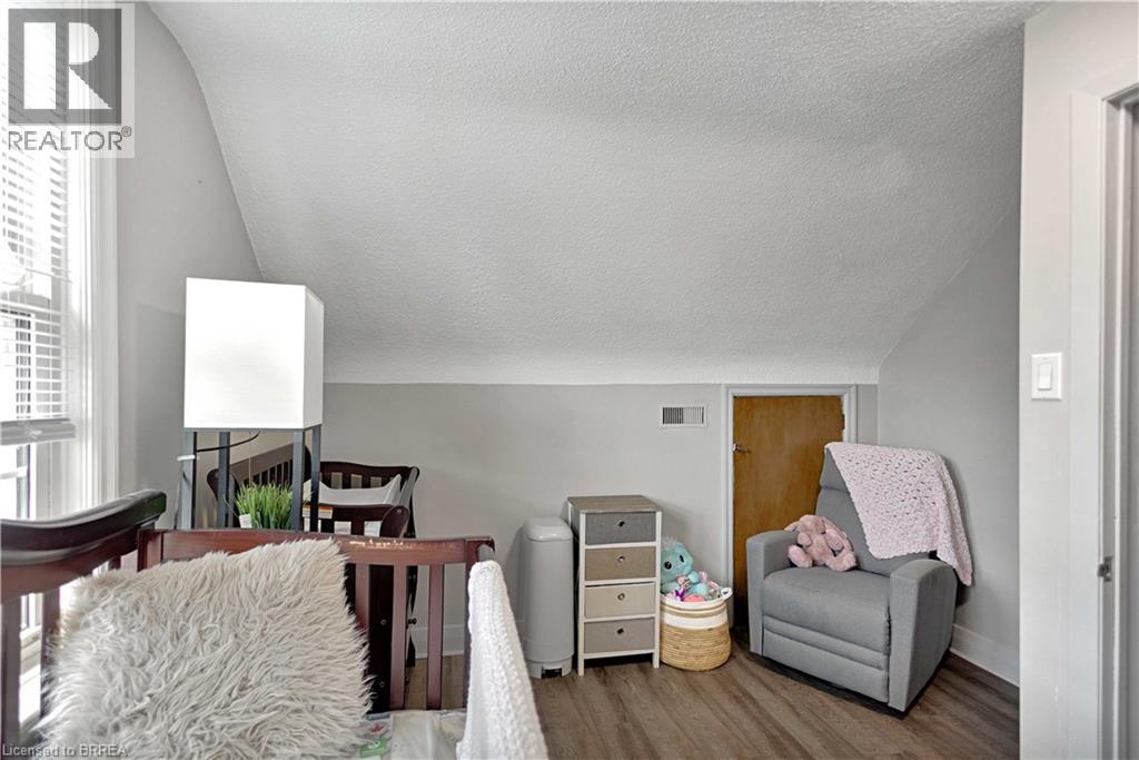 Room featuring sloped ceilings, wood-finish flooring, and a window with blinds - 371 Ottawa Street S, Kitchener, ON - Indoor With Fireplace