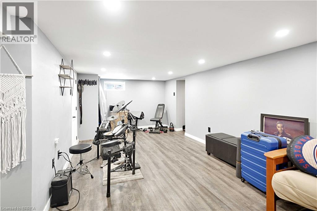 Spacious interior room featuring light gray walls, recessed lighting, and wood-finish flooring - 371 Ottawa Street S, Kitchener, ON - Indoor