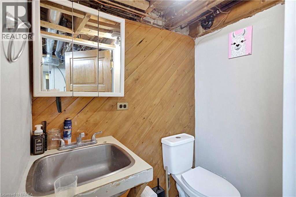 White wall-mounted medicine cabinet above a stainless steel sink with a chrome faucet - 371 Ottawa Street S, Kitchener, ON - Outdoor With Exterior
