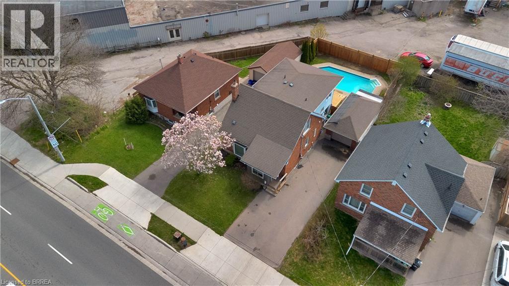 Aerial view of a brick residence featuring a private backyard with an in-ground pool, a detached garage, and a mature flowering tree - 371 Ottawa Street S, Kitchener, ON - Outdoor