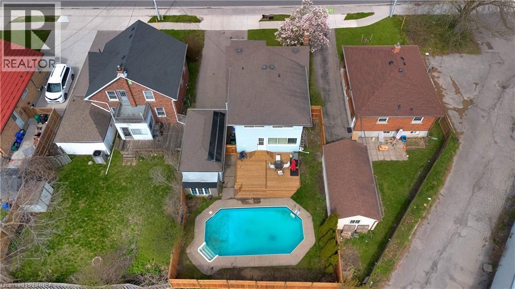 Rear exterior featuring an inground swimming pool, expansive wood deck, and solar panels - 371 Ottawa Street S, Kitchener, ON - Outdoor With In Ground Pool