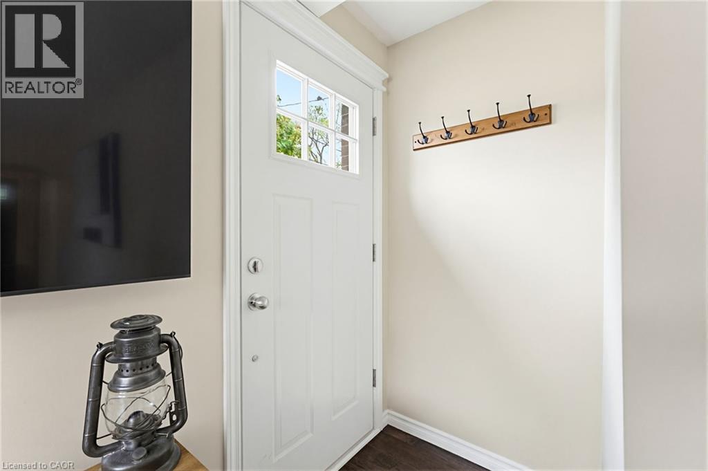 Entryway featuring a white paneled door with glass inserts, wood-finish flooring, and a wall-mounted coat rack - 60 Avenue Road, Cambridge, ON - Indoor Photo Showing Other Room
