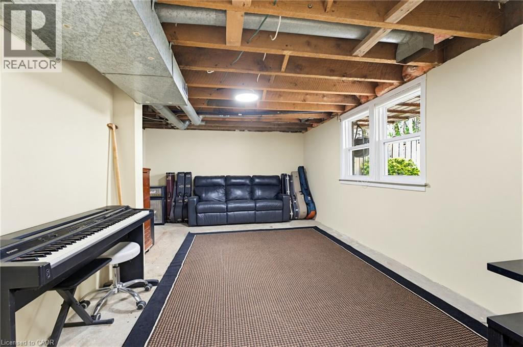 Lower level space featuring exposed ceiling joists and ductwork, painted walls, carpeted floor area, and two double-hung windows - 60 Avenue Road, Cambridge, ON - Indoor