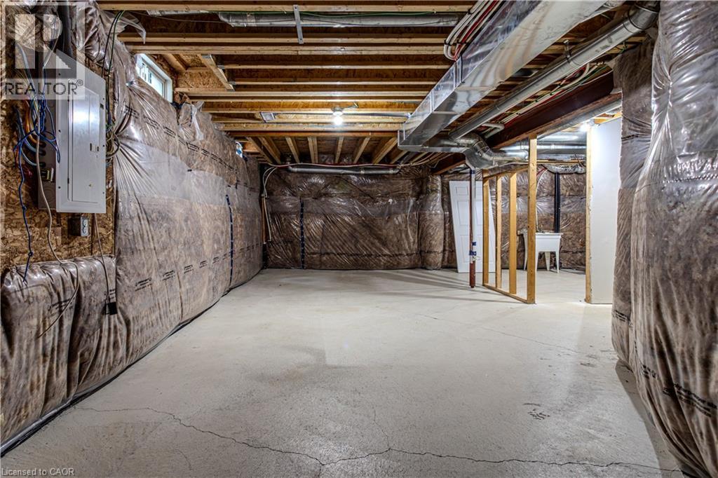 Unfinished basement featuring exposed wood joists, concrete flooring, and a utility sink - 3896 Tufgar Crescent, Burlington, ON - Indoor Photo Showing Basement