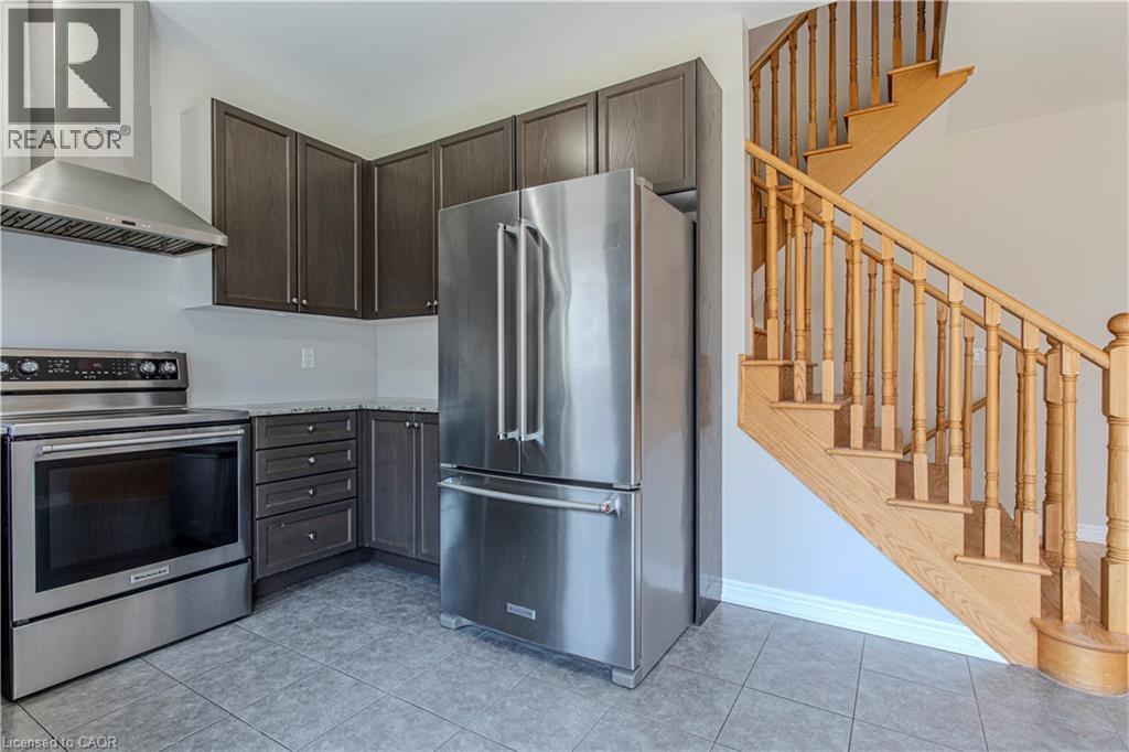 Kitchen featuring stainless steel appliances, dark wood cabinetry, and a light-toned countertop - 3896 Tufgar Crescent, Burlington, ON - Indoor Photo Showing Kitchen With Stainless Steel Kitchen