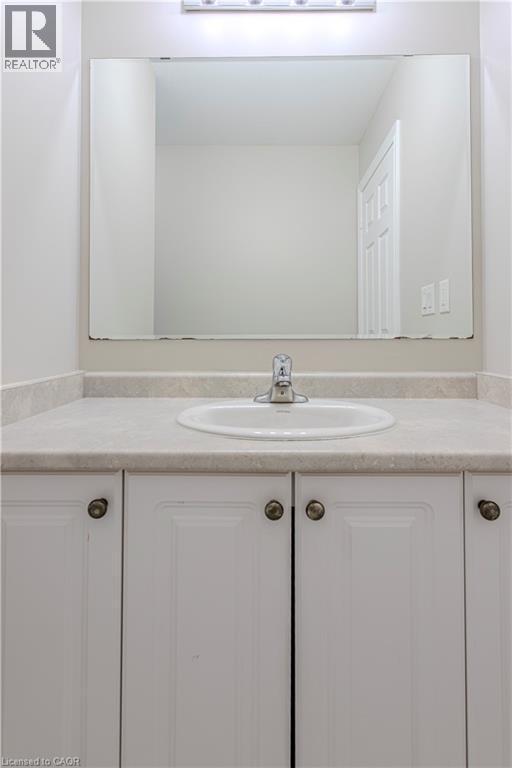Bathroom vanity featuring a white oval sink, chrome faucet, and integrated light fixture - 3896 Tufgar Crescent, Burlington, ON - Indoor Photo Showing Bathroom