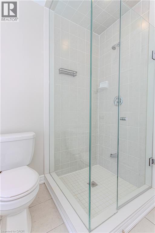 Glass-enclosed shower featuring white square tile walls, a small square tile floor, and chrome fixtures - 3896 Tufgar Crescent, Burlington, ON - Indoor Photo Showing Bathroom