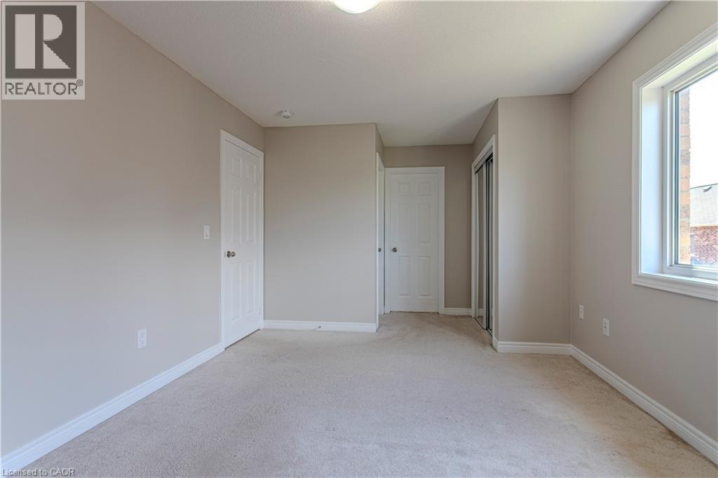 Spacious room featuring neutral-toned walls, white trim, and light-colored carpeting - 3896 Tufgar Crescent, Burlington, ON - Indoor Photo Showing Other Room