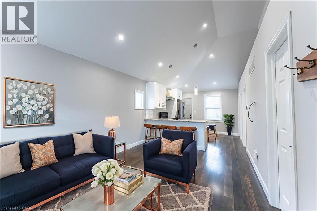 Living area featuring vaulted ceiling, dark wood-type flooring, and recessed lighting - 222 Kensington Avenue N, Hamilton, ON - Indoor Photo Showing Living Room