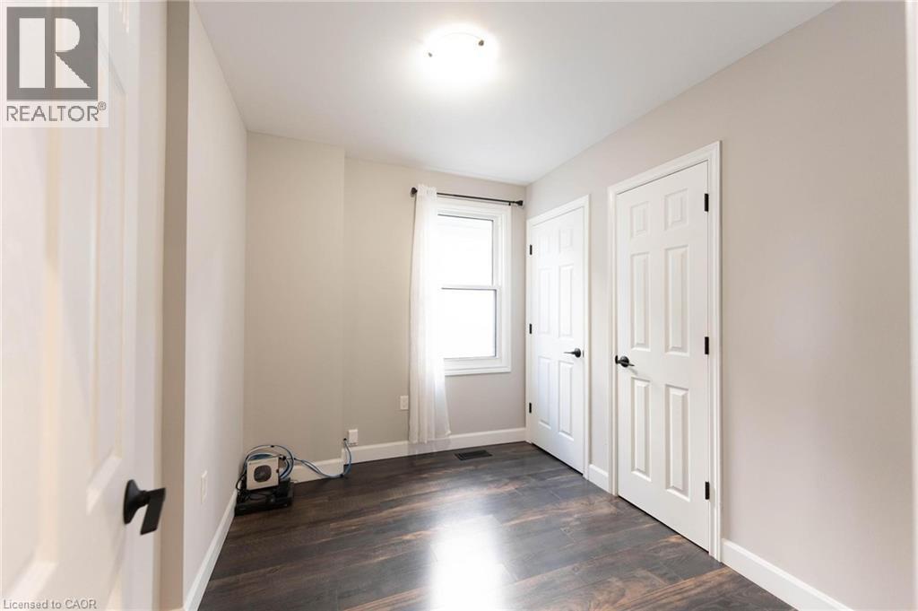 Unfurnished bedroom with baseboards and dark wood finished floors - 222 Kensington Avenue N, Hamilton, ON - Indoor Photo Showing Other Room