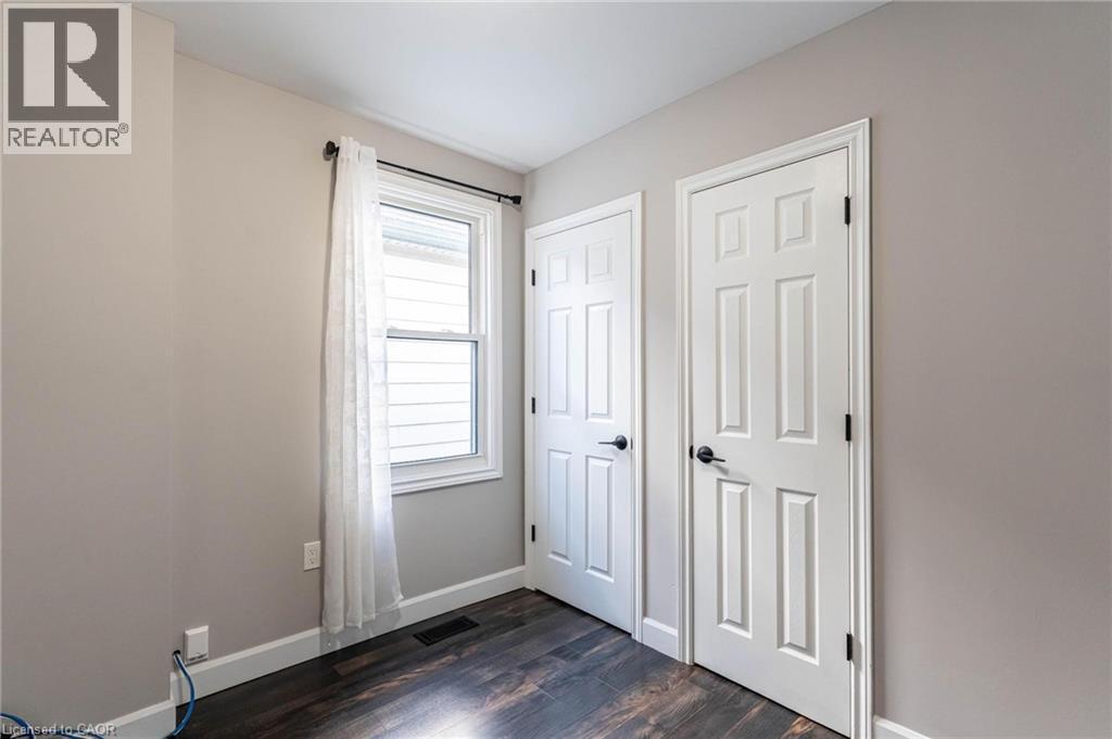 Unfurnished bedroom with baseboards and dark wood-type flooring - 222 Kensington Avenue N, Hamilton, ON - Indoor Photo Showing Other Room