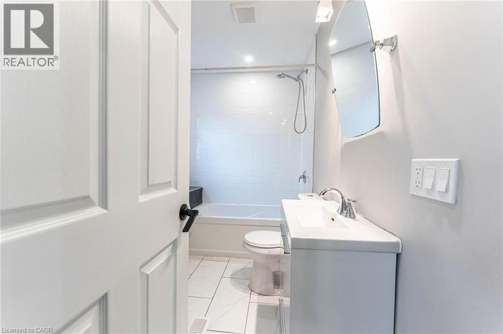 Full bathroom with vanity, light marble finish flooring, and bathing tub / shower combination - 222 Kensington Avenue N, Hamilton, ON - Indoor Photo Showing Bathroom
