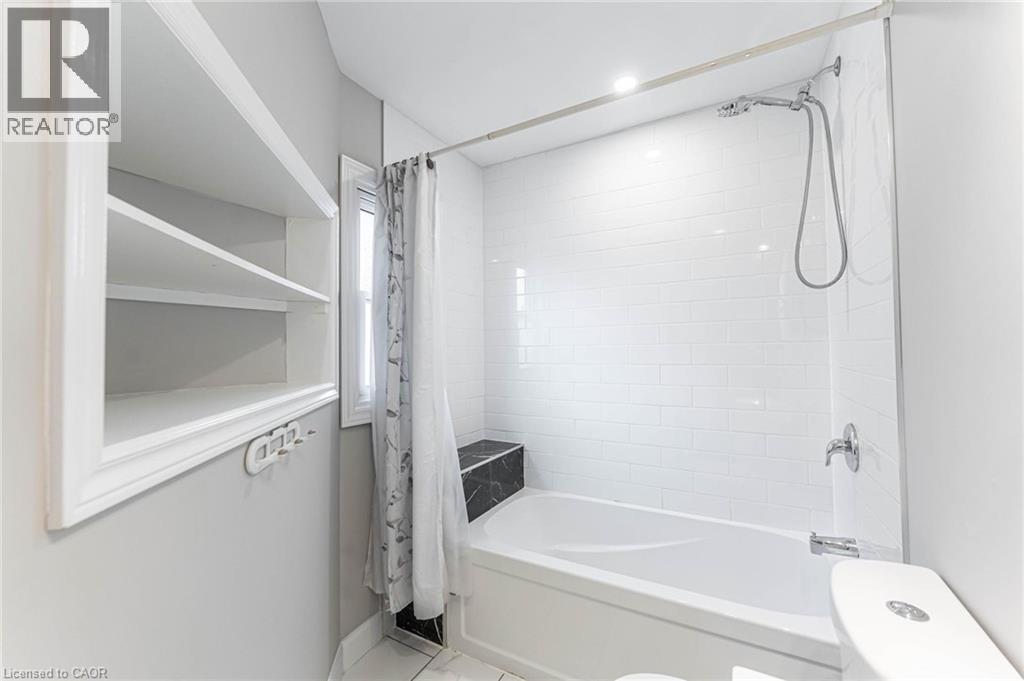 Full bath with shower / bath combo with shower curtain and tile patterned flooring - 222 Kensington Avenue N, Hamilton, ON - Indoor Photo Showing Other Room