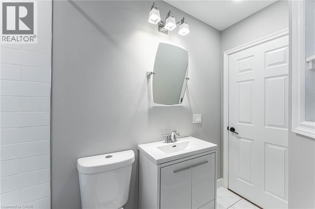 Half bath with vanity and light tile patterned flooring - 222 Kensington Avenue N, Hamilton, ON - Indoor Photo Showing Bathroom