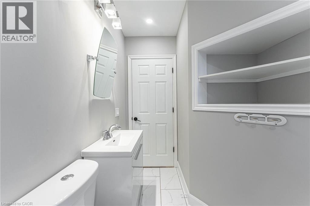 Bathroom featuring vanity and light marble finish floors - 222 Kensington Avenue N, Hamilton, ON - Indoor Photo Showing Laundry Room