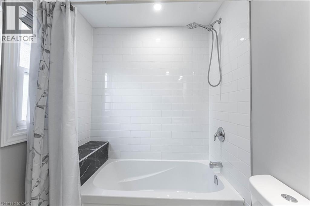 Full bathroom with shower / bath combo with shower curtain and toilet - 222 Kensington Avenue N, Hamilton, ON - Indoor Photo Showing Bathroom