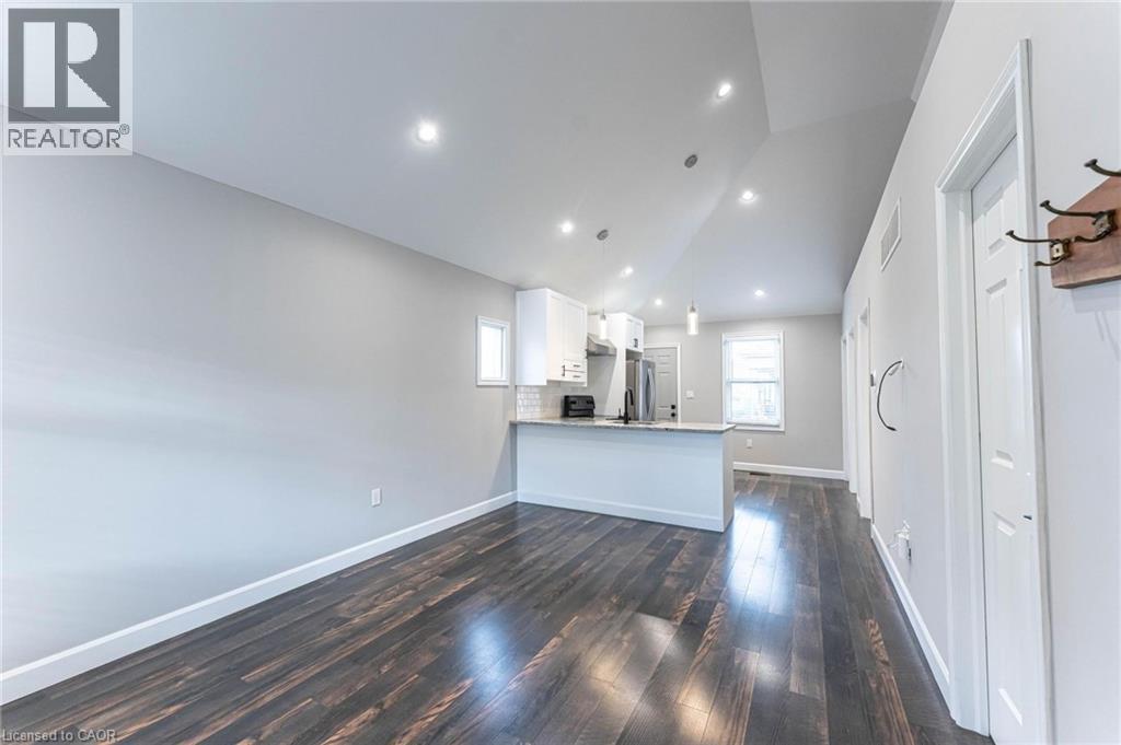 Unfurnished living room featuring lofted ceiling, dark wood-style flooring, and recessed lighting - 222 Kensington Avenue N, Hamilton, ON - Indoor Photo Showing Other Room