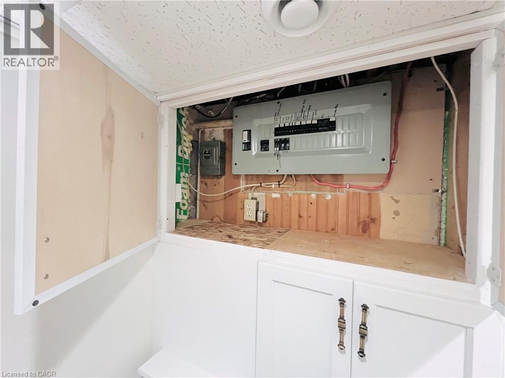 Utility access panel featuring a visible electrical service panel and concealed storage below - 56 Eastvale Place, Hamilton, ON - Indoor