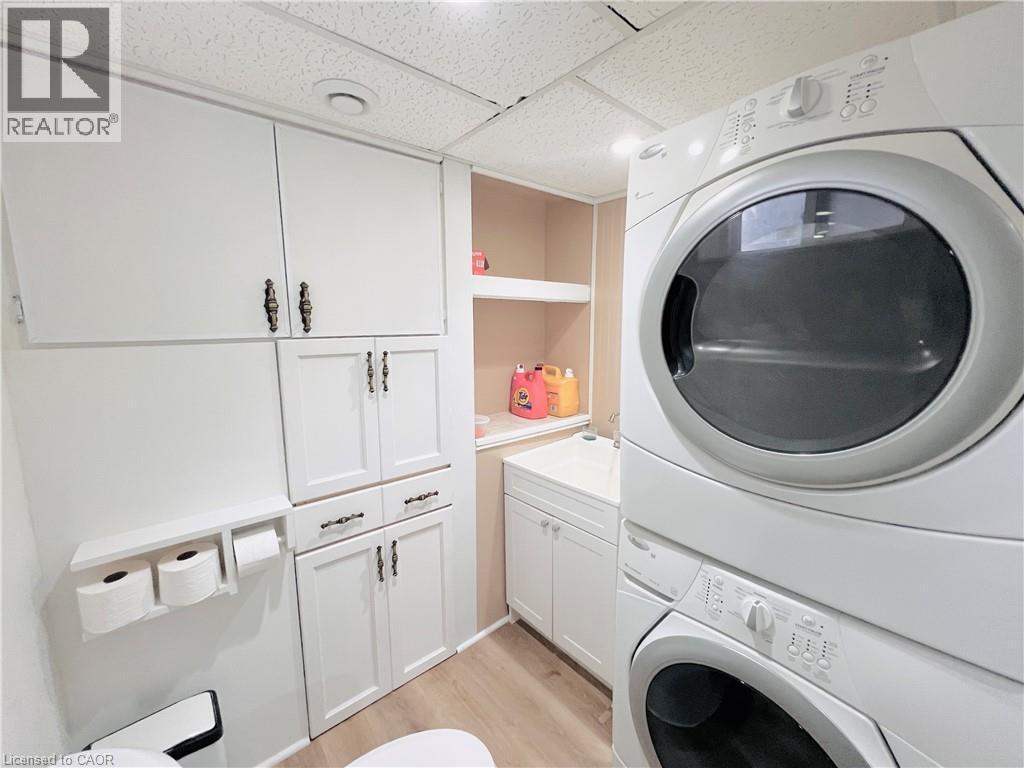 Dedicated laundry area featuring a stacked washer and dryer unit - 56 Eastvale Place, Hamilton, ON - Indoor Photo Showing Laundry Room