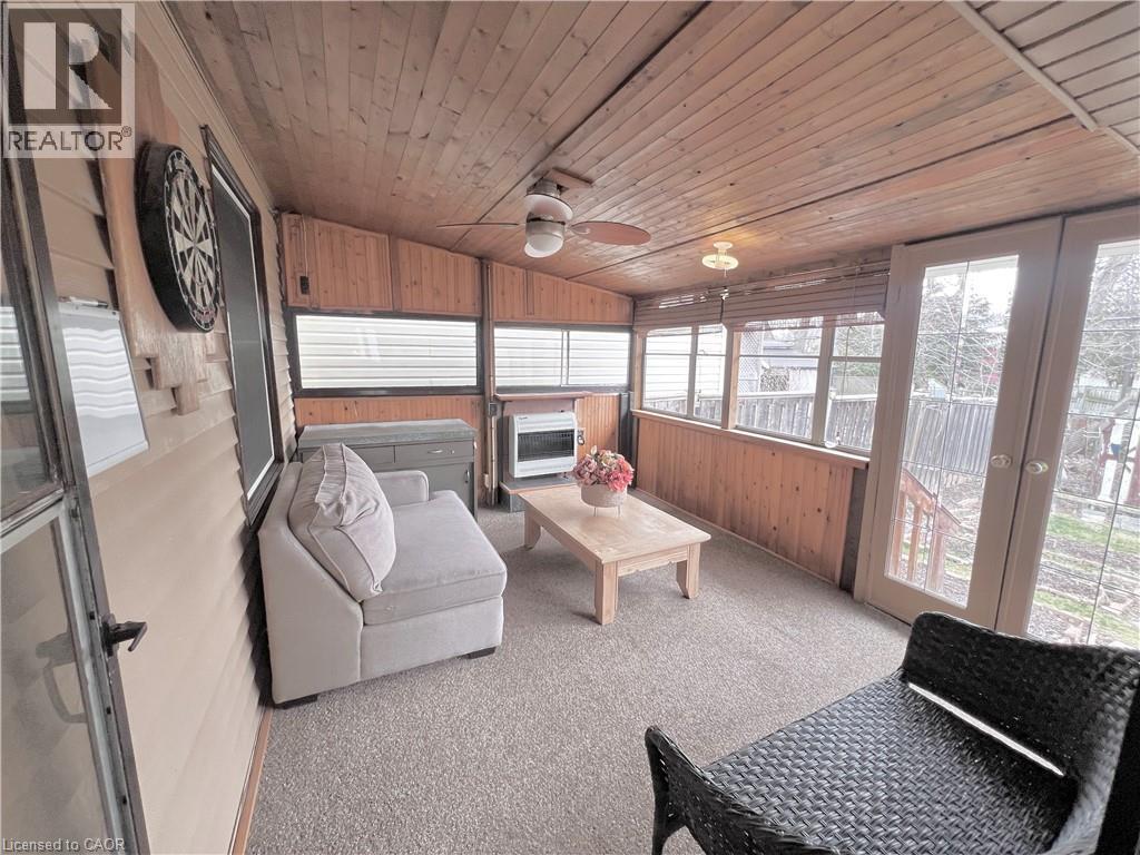 Enclosed porch featuring wood-panel walls, wood-plank ceiling, and a ceiling fan - 56 Eastvale Place, Hamilton, ON - Indoor Photo Showing Other Room
