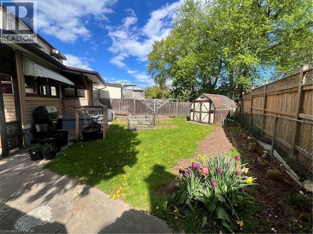 Expansive backyard featuring a lush lawn, mature trees, a garden shed, and established garden beds - 56 Eastvale Place, Hamilton, ON - Outdoor