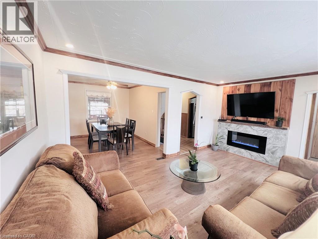 Spacious living area featuring wood-finish flooring, recessed lighting, and crown molding - 56 Eastvale Place, Hamilton, ON - Indoor Photo Showing Living Room With Fireplace