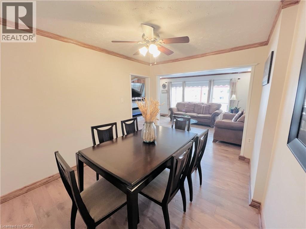 Dining area featuring wood-finish flooring, crown molding, and a ceiling fan with integrated lighting - 56 Eastvale Place, Hamilton, ON - Indoor Photo Showing Dining Room