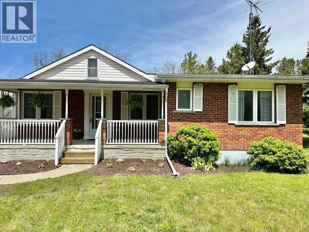 Brick and siding exterior with a covered front porch featuring white railing - 165 Highway 6, Simcoe, ON - Outdoor