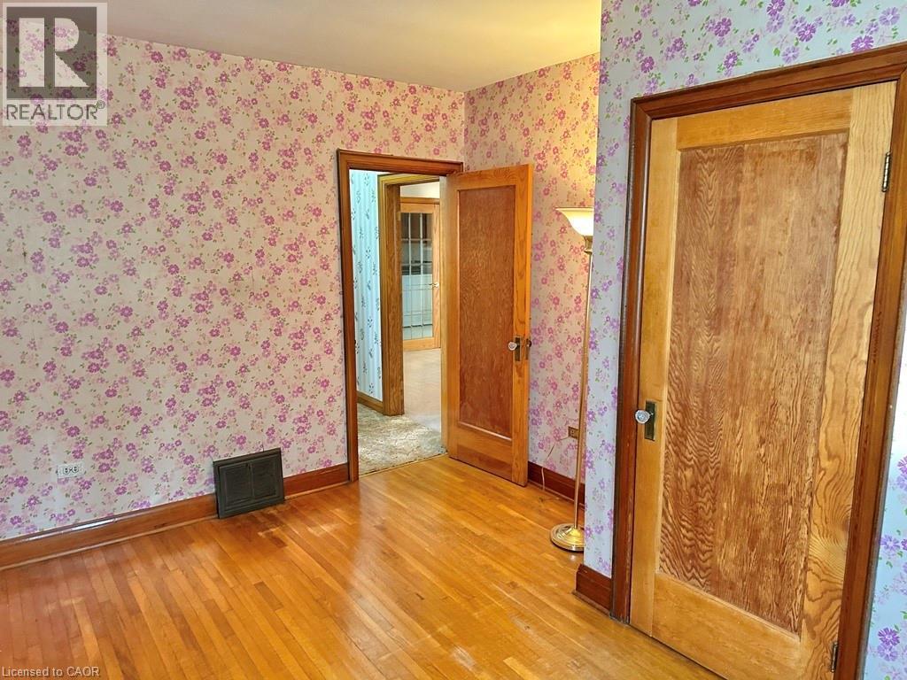 Hardwood flooring throughout featuring wood trim and solid wood doors with traditional hardware - 165 Highway 6, Simcoe, ON - Indoor Photo Showing Other Room