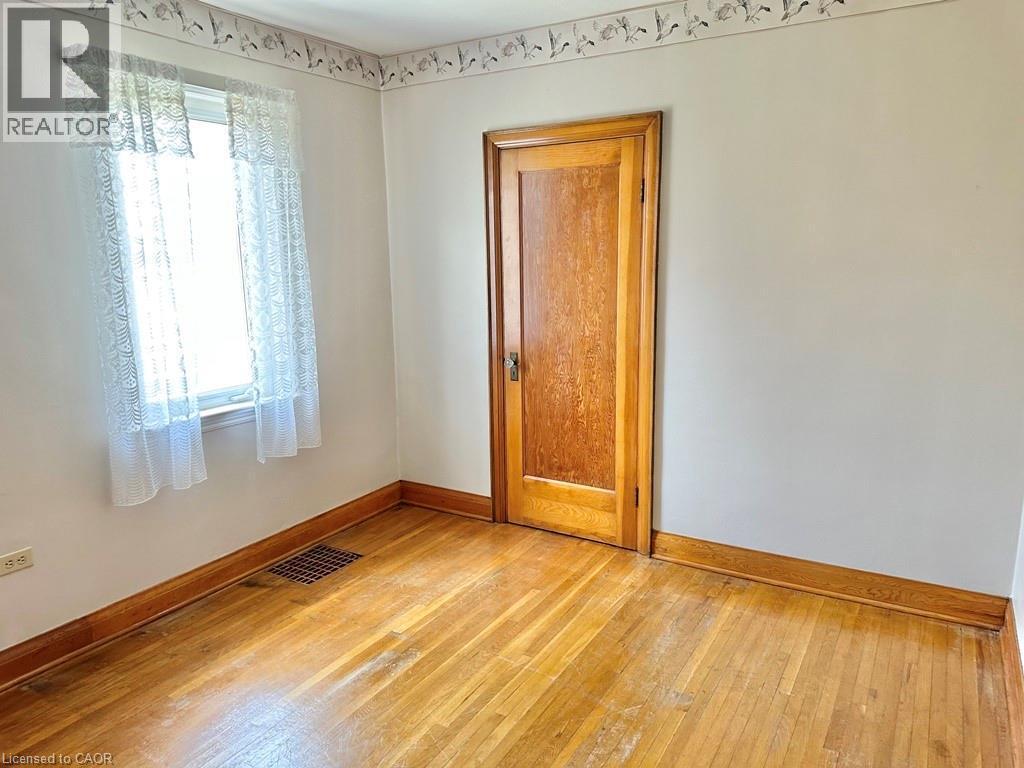 Hardwood flooring with natural wood baseboards - 165 Highway 6, Simcoe, ON - Indoor Photo Showing Other Room