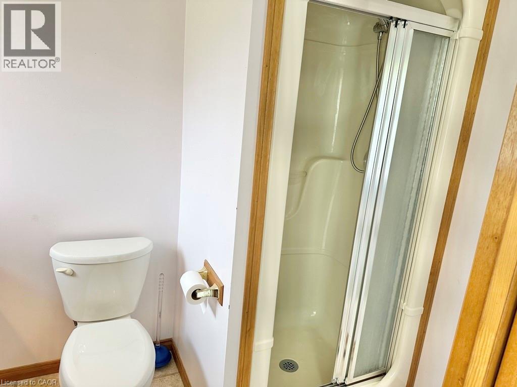 Enclosed shower stall with a sliding glass door and white fiberglass surround - 165 Highway 6, Simcoe, ON - Indoor Photo Showing Bathroom