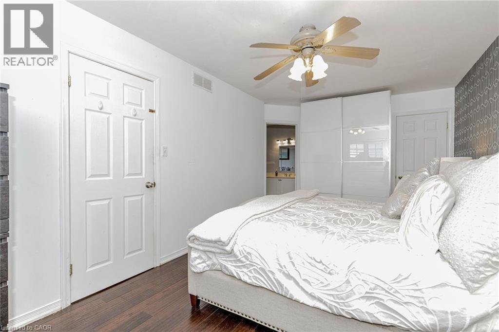 Bedroom with ensuite bath, dark wood-type flooring, a closet, and ceiling fan - 32 Vineberg Drive, Hamilton, ON - Indoor Photo Showing Bedroom