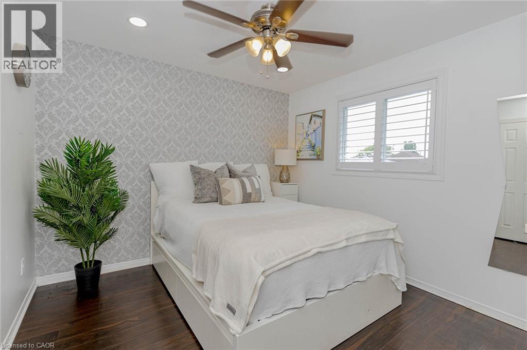 Bedroom featuring wallpapered walls, an accent wall, dark wood finished floors, a ceiling fan, and recessed lighting - 32 Vineberg Drive, Hamilton, ON - Indoor Photo Showing Bedroom