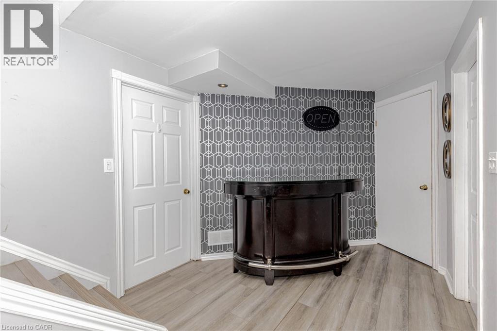 Detailed view of wood finished floors and an accent wall - 32 Vineberg Drive, Hamilton, ON - Indoor Photo Showing Other Room