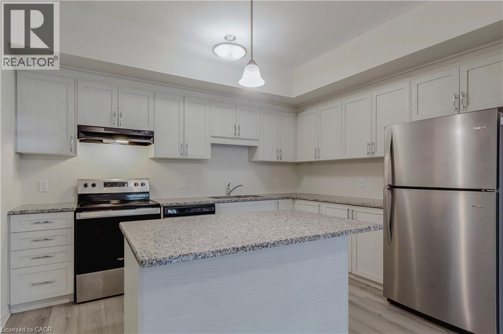 Kitchen featuring light wood-style flooring, a kitchen island, under cabinet range hood, stainless steel appliances, and a sink - 25 Isherwood Avenue Unit# G-105, Cambridge, ON - Indoor Photo Showing Kitchen With Stainless Steel Kitchen