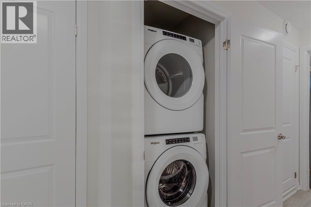 Laundry area with laundry area and stacked washer / drying machine - 25 Isherwood Avenue Unit# G-105, Cambridge, ON - Indoor Photo Showing Laundry Room
