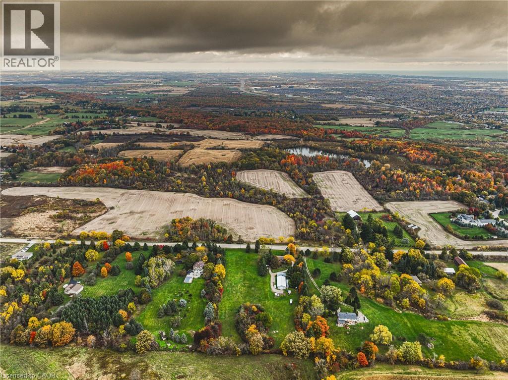 Aerial landscape featuring expansive fields, dense tree lines with autumnal foliage, and scattered residential properties - 3415 Cedar Springs Road, Burlington, ON