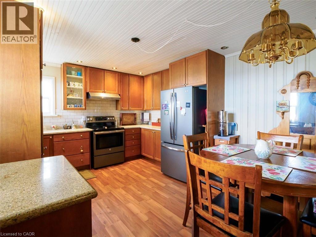 Kitchen to the left upon entering features wood cabinetry, stainless steel appliances, white subway tile backsplash - 1395 Lakeshore Road, Haldimand County, ON - Indoor