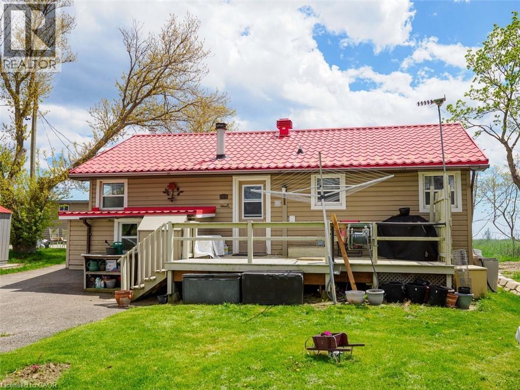 Rear exterior featuring back door to utility/mud room. Generator on the rt. at back. Small covered metal roof on left leads with stairs inside down to 4 ft. Usable Storage crawl space. - 1395 Lakeshore Road, Haldimand County, ON - Outdoor With Deck Patio Veranda