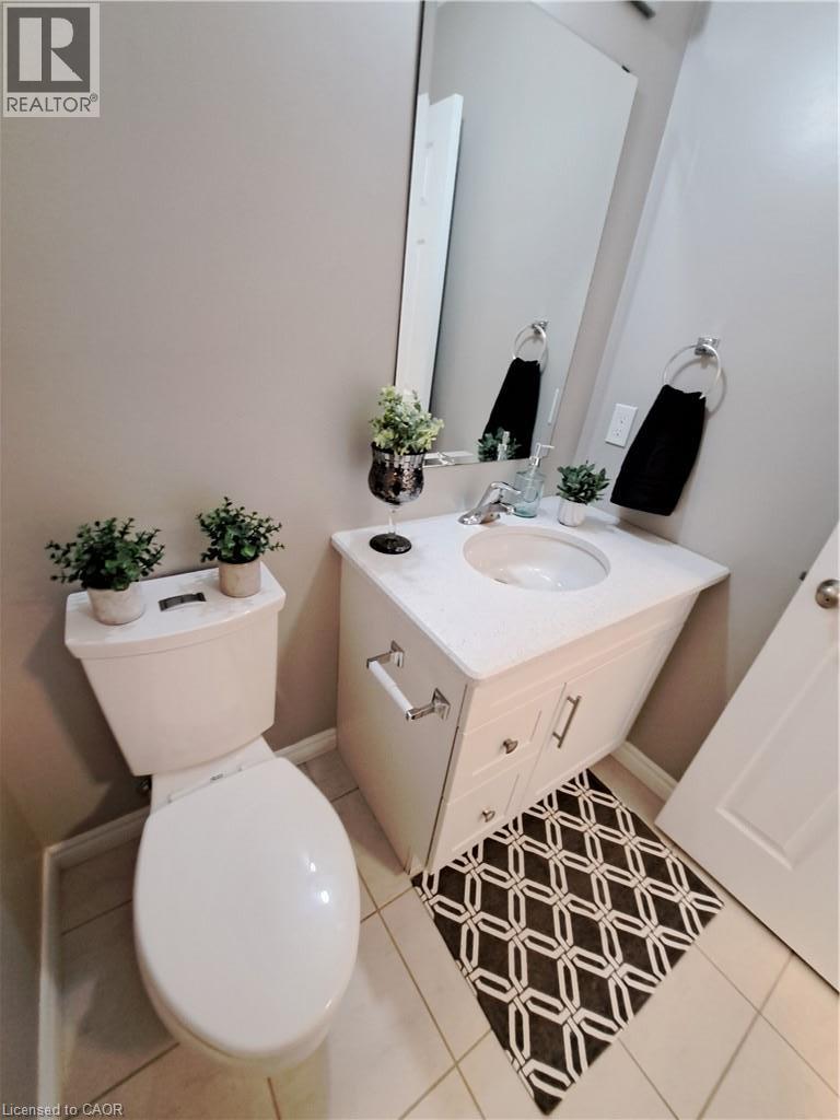 Bathroom featuring a white vanity with a built-in sink, chrome fixtures, and a wall-mounted mirror - 26 Wheat Lane, Kitchener, ON - Indoor Photo Showing Bathroom