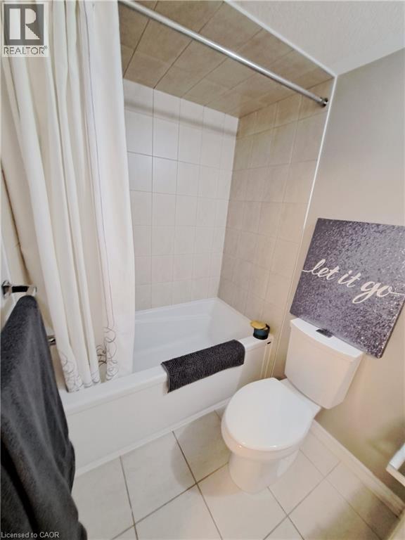 Bathroom featuring a white porcelain toilet, white bathtub, and light-toned ceramic tile flooring - 26 Wheat Lane, Kitchener, ON - Indoor Photo Showing Bathroom