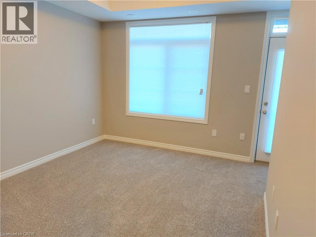 Neutral-toned wall paint and plush carpeting establish a comfortable ambiance - 26 Wheat Lane, Kitchener, ON - Indoor Photo Showing Other Room