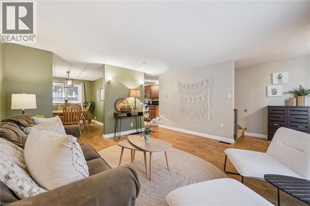 Wood-finish flooring throughout, bright recessed lighting, and a dining area with a window and a chandelier - 460 Parkview Crescent, Cambridge, ON - Indoor Photo Showing Living Room