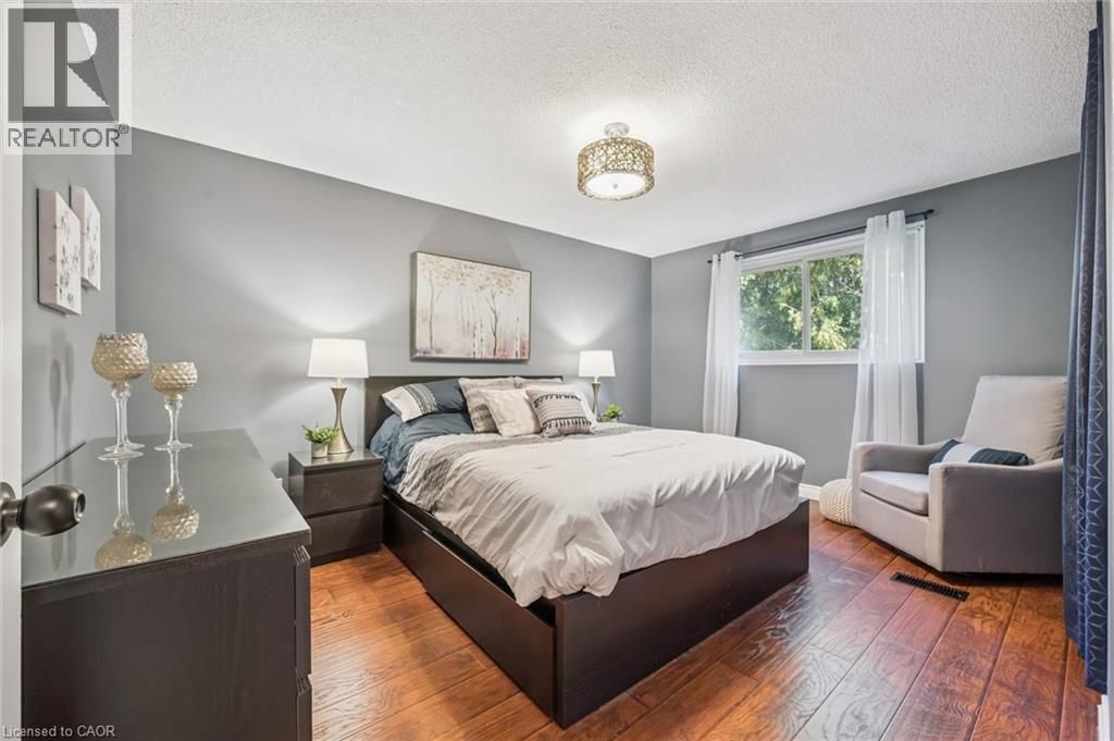 Wood-finish flooring, recessed window, and overhead decorative lighting fixture - 460 Parkview Crescent, Cambridge, ON - Indoor Photo Showing Bedroom