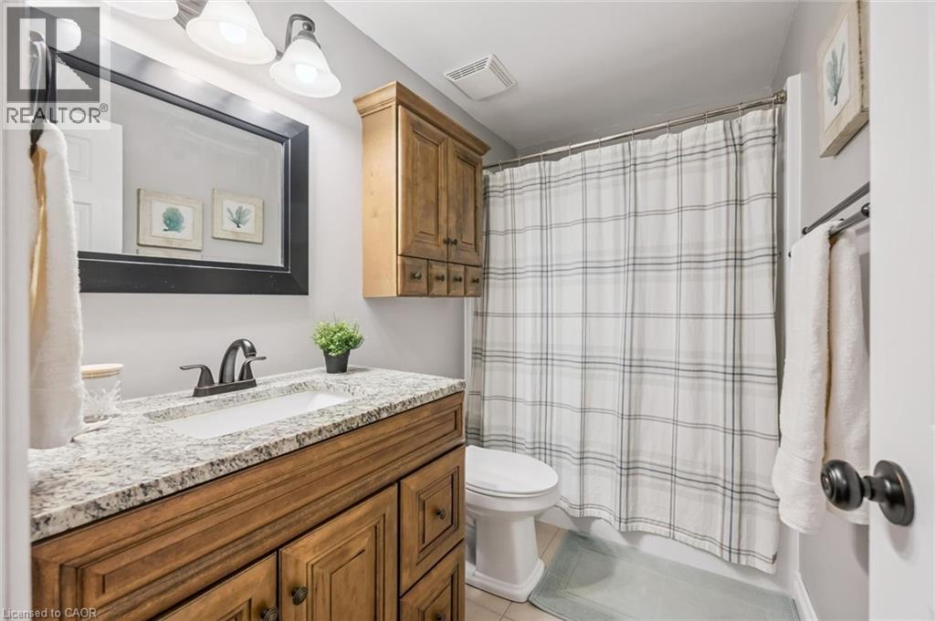 Wood-finish vanity with an integrated sink and light-toned countertop - 460 Parkview Crescent, Cambridge, ON - Indoor Photo Showing Bathroom