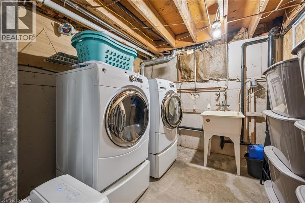 Laundry area featuring a utility sink, exposed ceiling joists, and concrete flooring - 460 Parkview Crescent, Cambridge, ON - Indoor Photo Showing Laundry Room