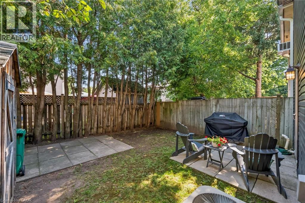 Private backyard featuring a concrete patio, wood fencing, and mature trees - 460 Parkview Crescent, Cambridge, ON - Outdoor