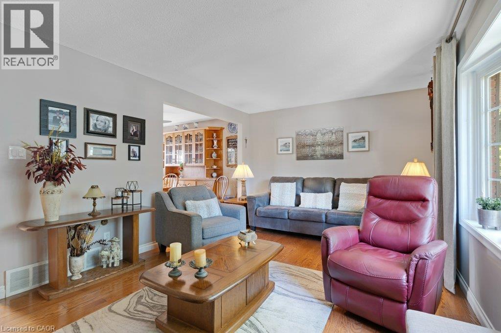 Hardwood-finish flooring throughout, light neutral wall paint, and a large bay window - 236 Winston Boulevard, Cambridge, ON - Indoor Photo Showing Living Room