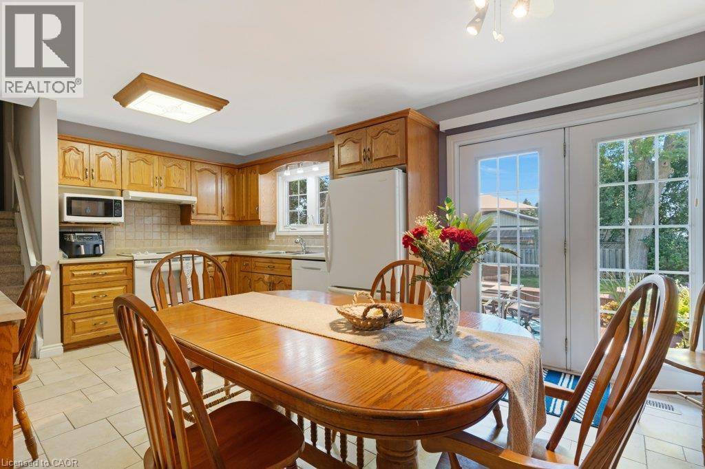 Kitchen with wood cabinetry, white appliances, and a tiled backsplash - 236 Winston Boulevard, Cambridge, ON - Indoor Photo Showing Dining Room